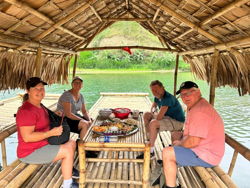 Tourists share a riverside meal on a thatched bamboo raft in Pu Luong, Thanh Hoa.